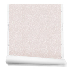 A hanging roll of wallpaper with a large-scale repeating leaf print in white on a light pink watercolor background.