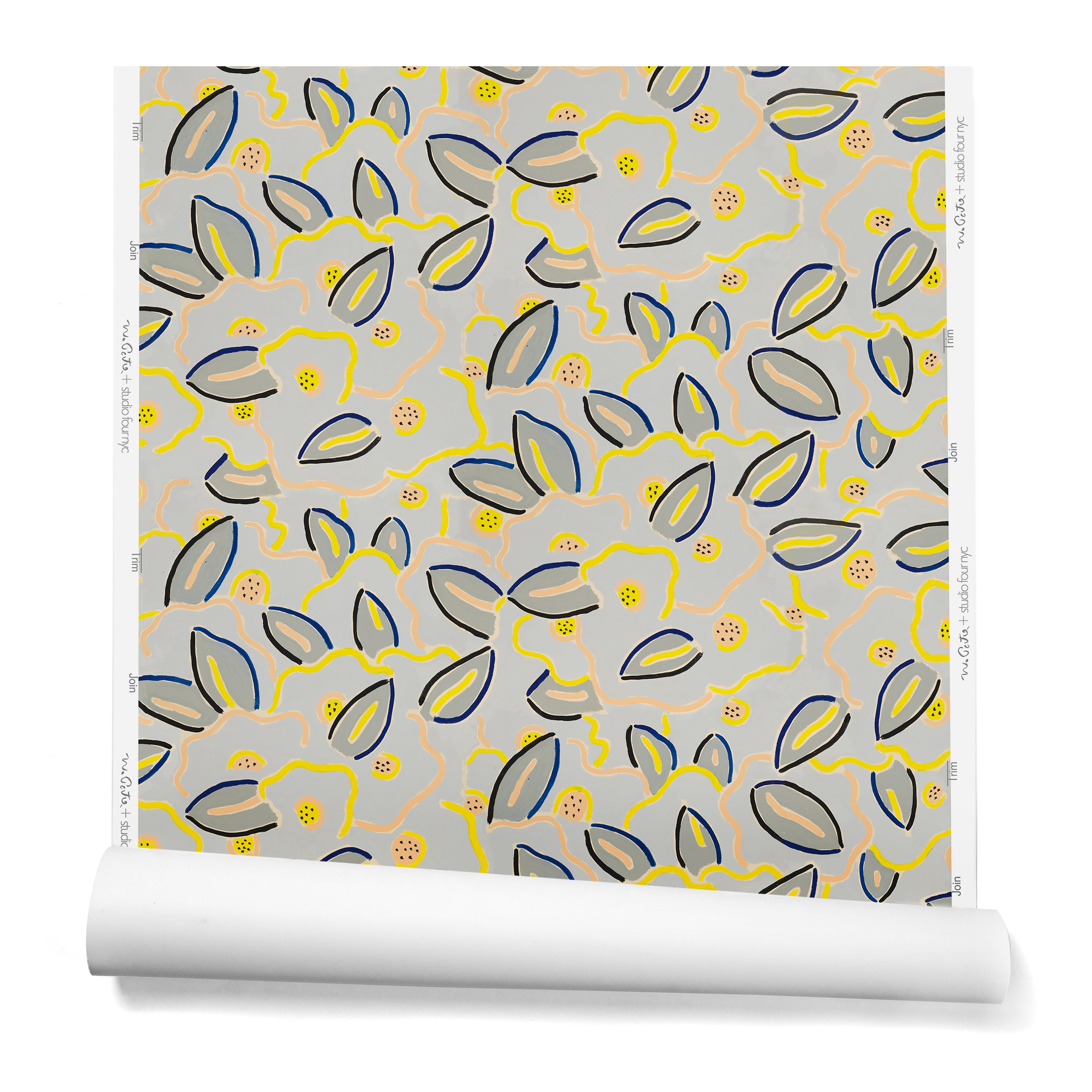 A hanging roll of wallpaper in a large-scale minimal floral print in shades of navy, yellow and pink on a gray-blue background.