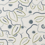 A swatch of fabric in a large-scale minimal floral print in shades of gray, navy and green on a tan background.