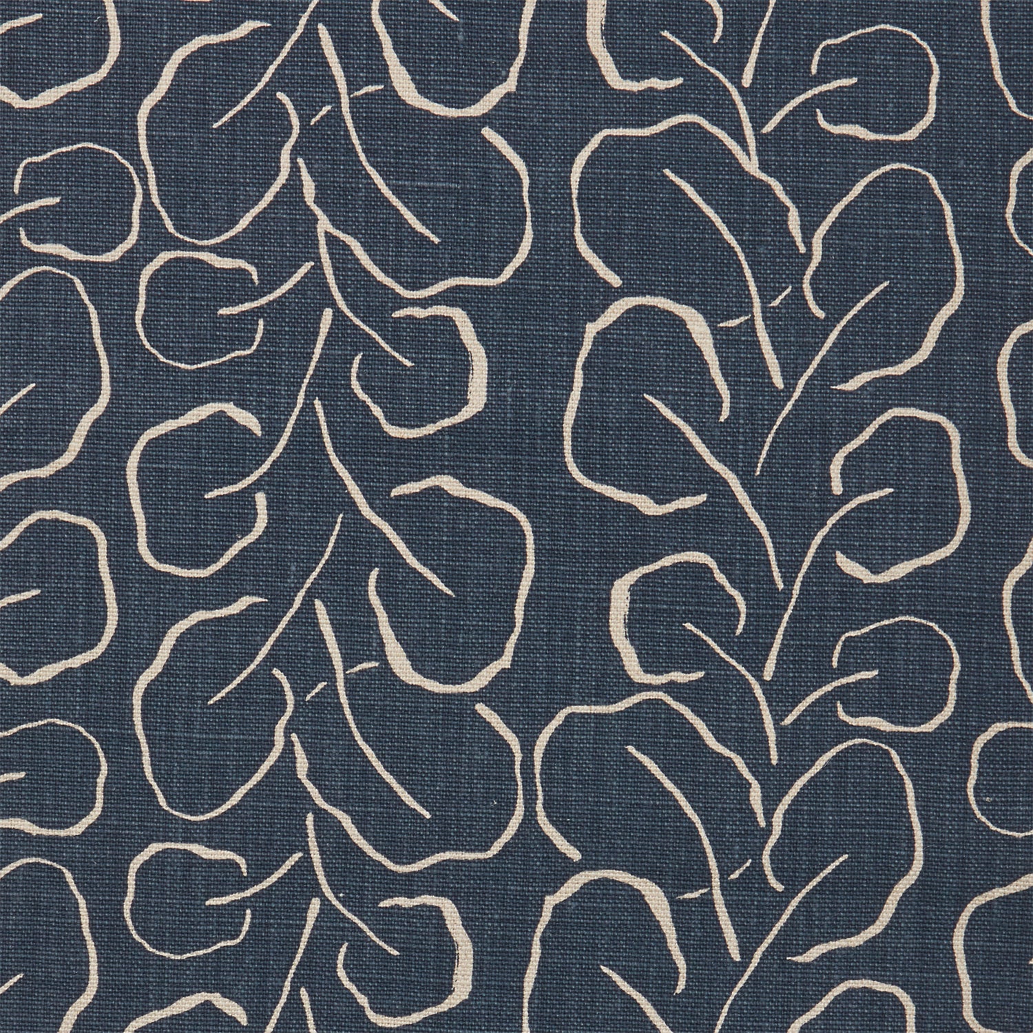 Woven fabric swatch with a large-scale repeating leaf print in tan on a navy blue background.